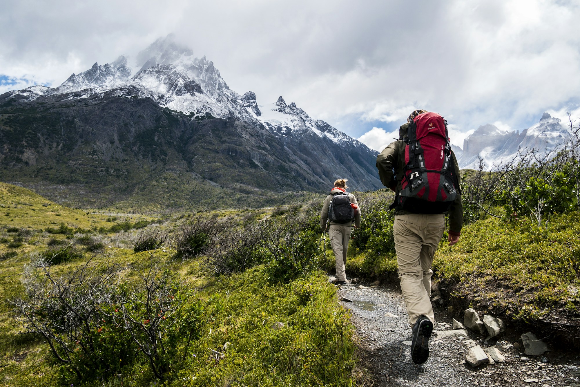 Marcheurs sur un sentier en montagne, au milieu des reliefs et des nuages